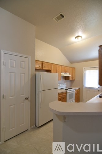 A kitchen with a white fridge and a white door.