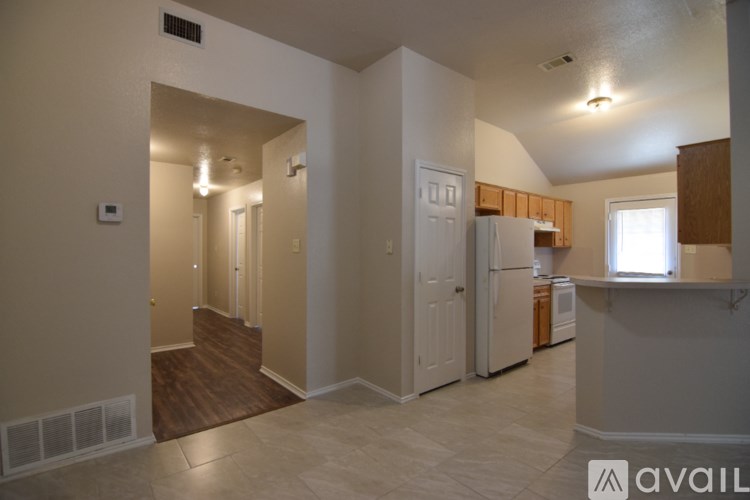 A kitchen with white appliances and wooden cabinets.
