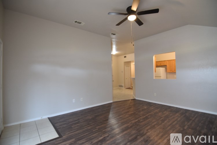 A room with a ceiling fan and wooden flooring.