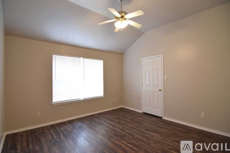 A room with a ceiling fan and a window with blinds.