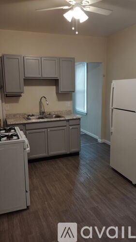 A kitchen with a white fridge and cabinets.