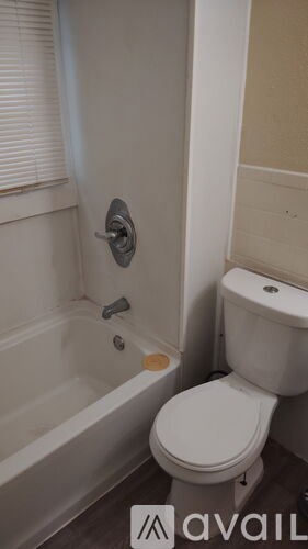 A white toilet sits next to a bathtub in a bathroom.