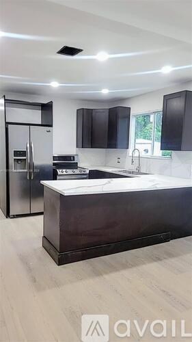 A modern kitchen with a refrigerator, stove, and sink.