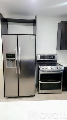 A stainless steel refrigerator and oven in a kitchen.