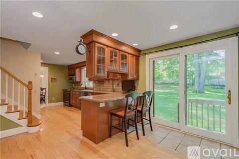 A kitchen with wooden cabinets and a large island with chairs.