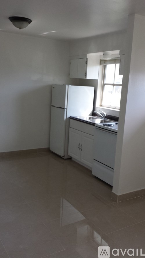 A kitchen with white appliances and cabinets.