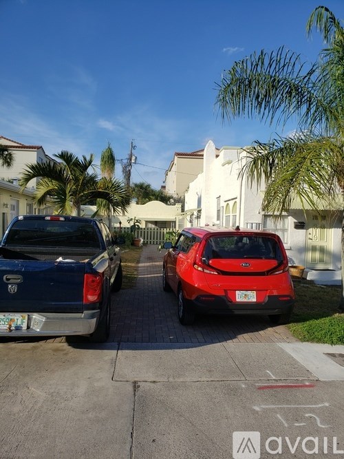 A red car is parked on the right side of a street.