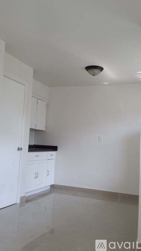 A kitchen with white cabinets and a black countertop.