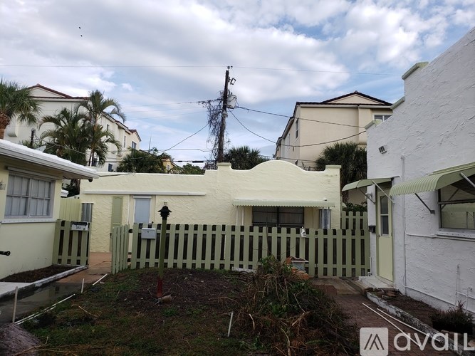 A white house with a green fence in front of it.