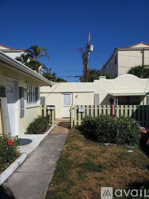 A residential street with houses on both sides and a clear blue sky.
