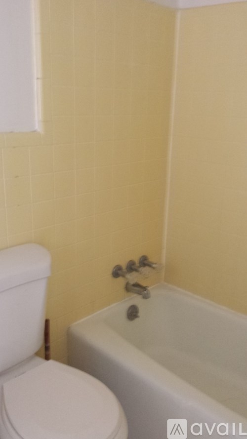 A white toilet sits next to a bathtub in a bathroom.