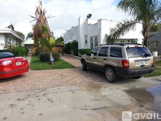 A tan station wagon is parked on a driveway.