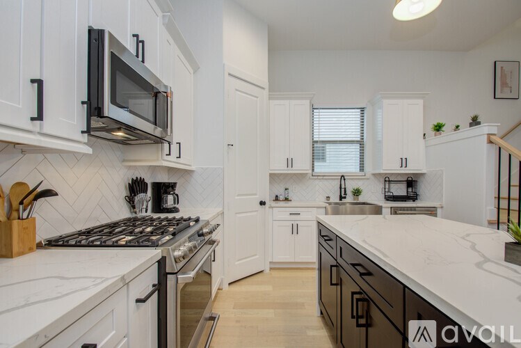 A kitchen with white cabinets and a black stove top.