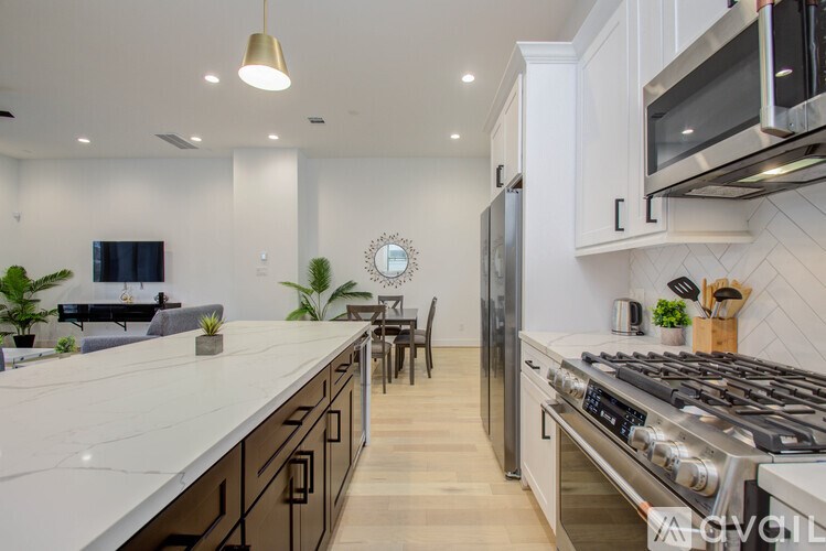 A modern kitchen with a stainless steel stove and white countertops.