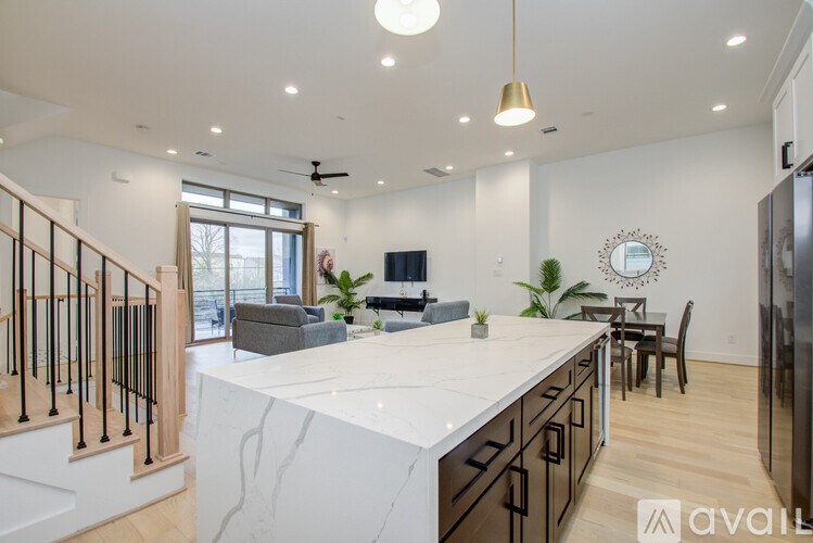 A modern kitchen with a marble countertop and stainless steel appliances.