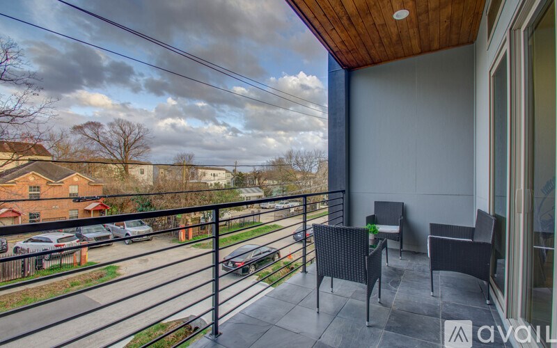 A balcony with a table and chairs overlooking a street.