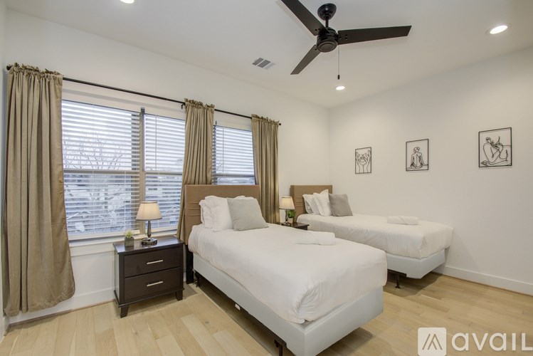 A bedroom with two beds and a ceiling fan.