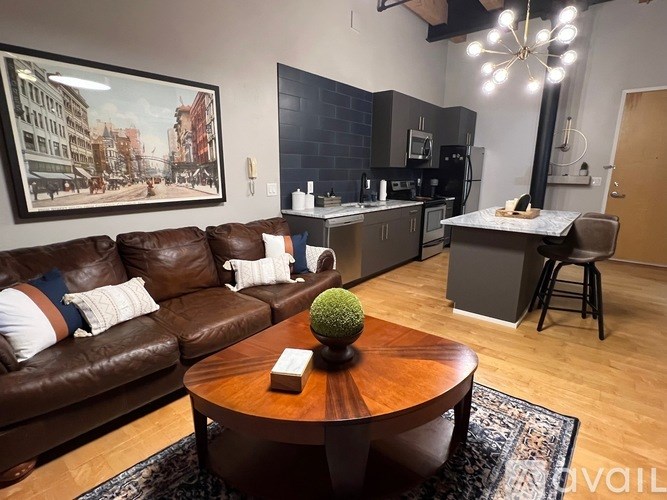 A brown leather couch with a wooden coffee table in front of it.