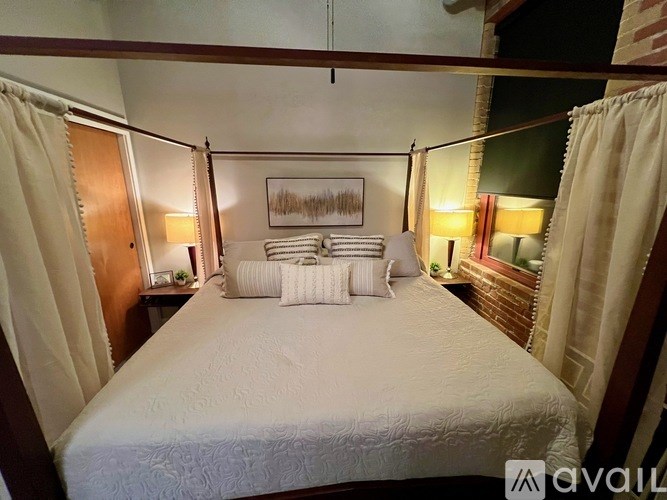 A bedroom with a bed, nightstands, and a painting on the wall.