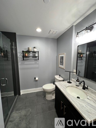 A bathroom with a toilet, sink, and mirror.