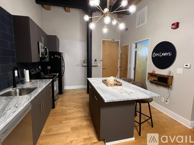 A kitchen with a marble countertop and wooden floors.