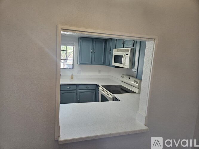 A kitchen with a microwave and oven built into the cabinetry.