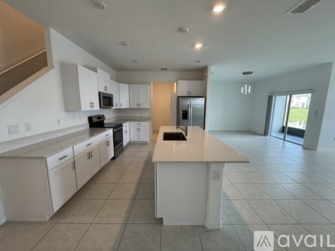 A spacious kitchen with white cabinets and a central island.