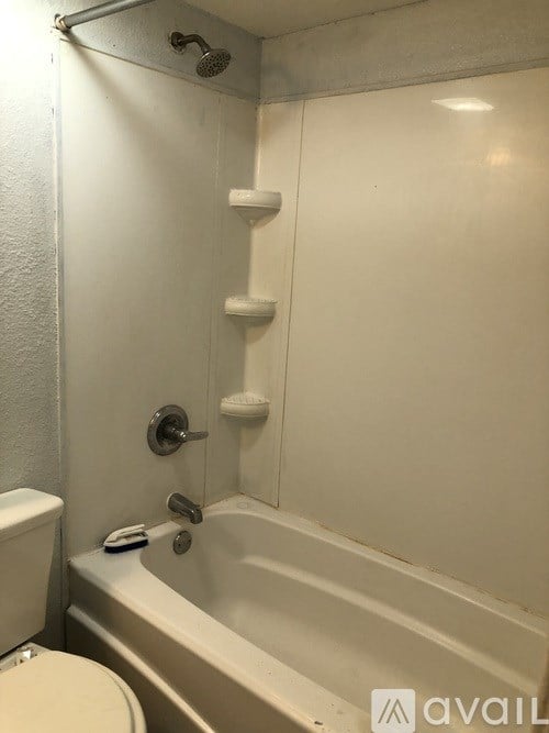 A white bathroom with a toilet, tub, and shower.