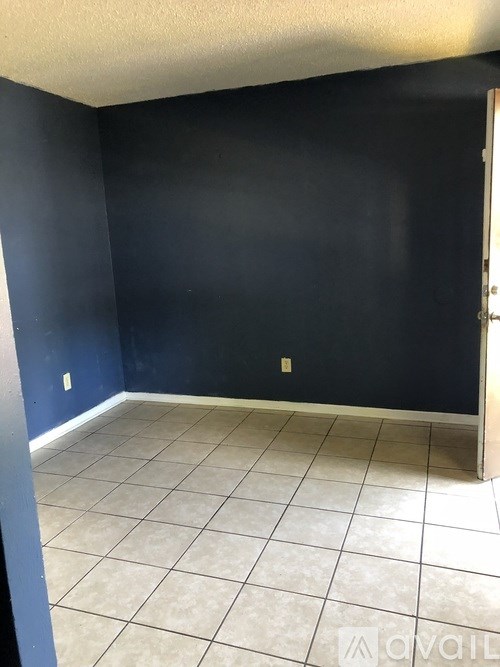 A room with dark blue walls and white tiled flooring.