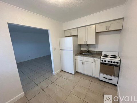 A kitchen with white appliances and cabinets.