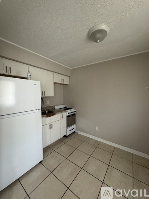 A kitchen with white appliances and white cabinets.