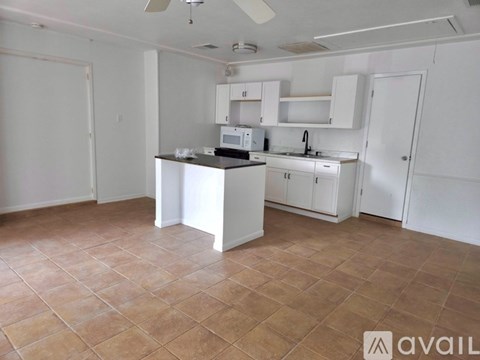 A kitchen with white cabinets and a tiled floor.