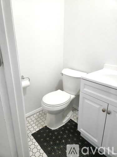 A white toilet sits next to a white cabinet in a bathroom.