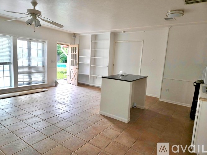A room with a ceiling fan and tile flooring.