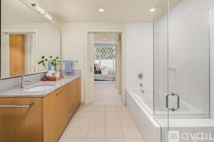 A bathroom with a walk-in shower and a double sink vanity.