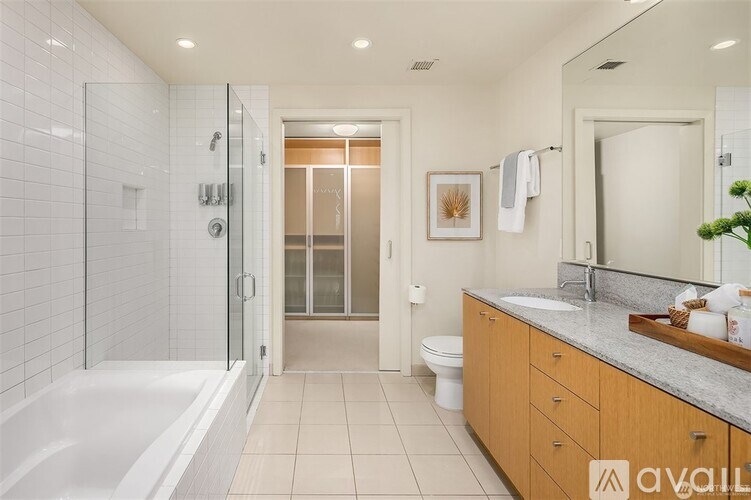 A bathroom with a walk-in shower, toilet, and sink.