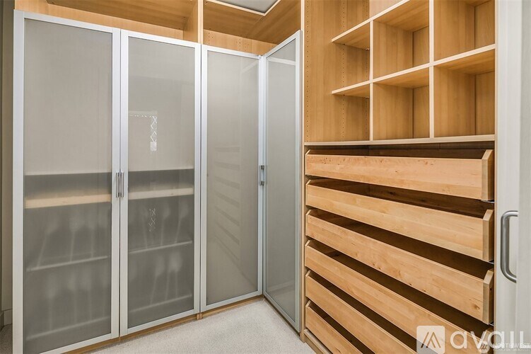 A room with a glass door and a wooden shelving unit.
