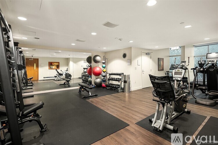 A gym with a variety of equipment including weights and cardio machines.