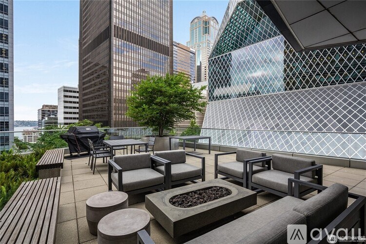A patio with a table and chairs overlooking a cityscape.