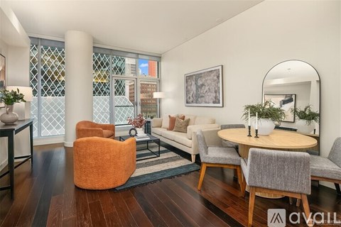 A living room with a round orange chair and a round wooden table with chairs around it.