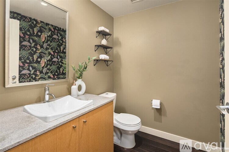 A bathroom with a sink, toilet, and a mirror.