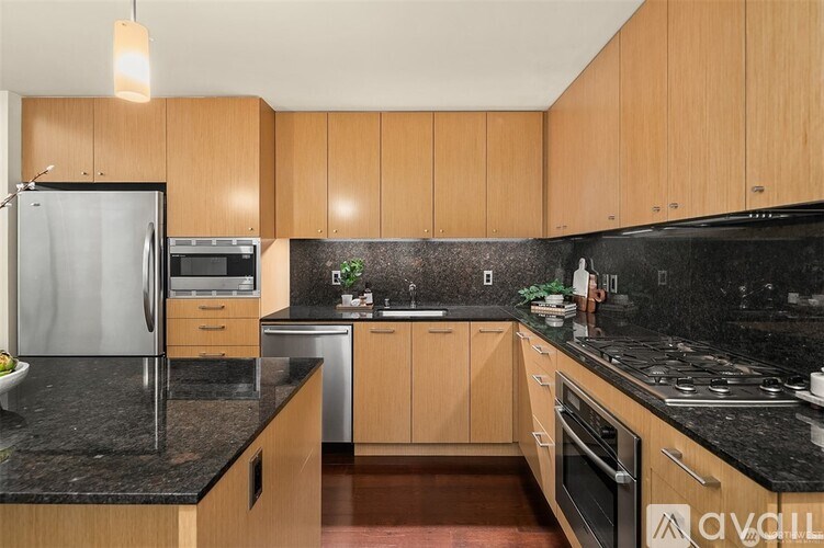 A kitchen with wooden cabinets and black countertops.
