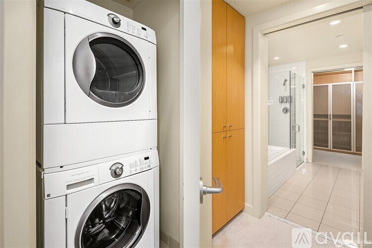 A white front loading washing machine is in a kitchen.