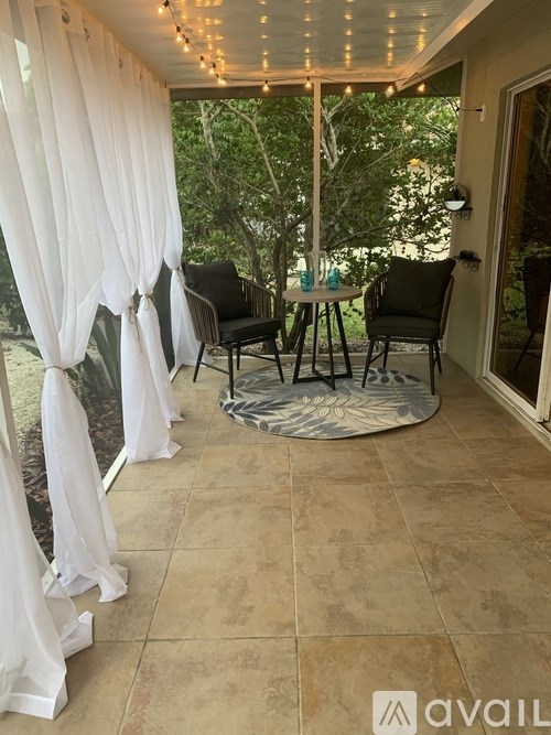 A patio with a table and chairs under a canopy.