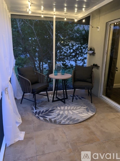 A patio with a table and chairs and a white canopy.