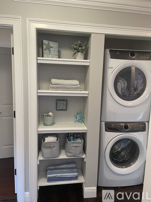 A white cabinet with a washer and dryer in it.
