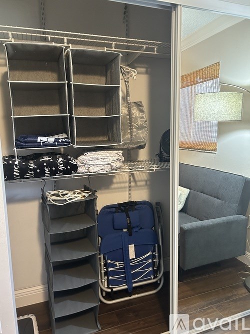 A grey suitcase is on the floor next to a grey chair.