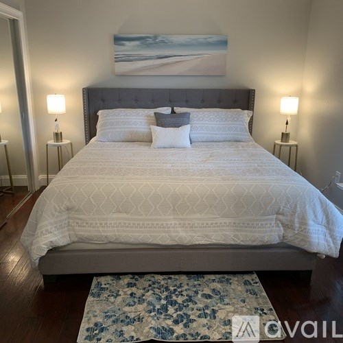 A bed with a white comforter and two white pillows is in the image.