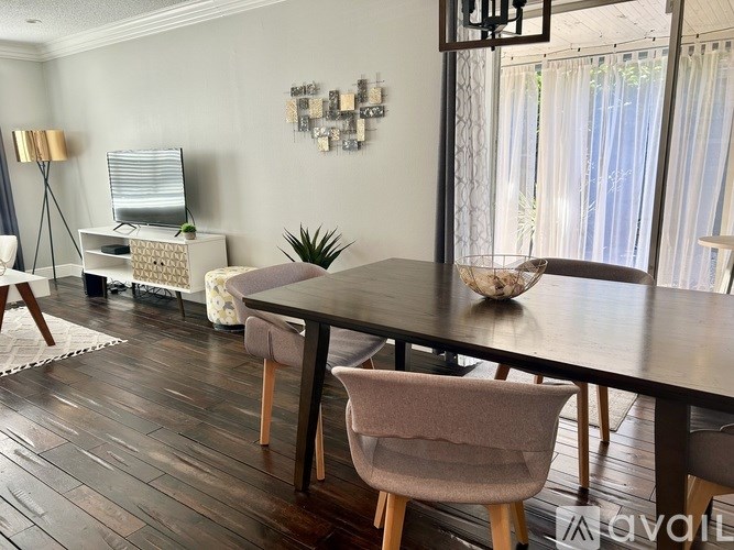 A modern dining room with a wooden table and chairs.