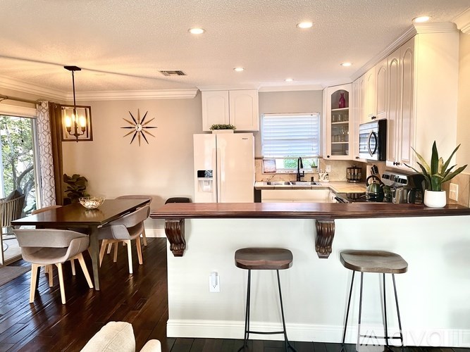 A kitchen with a bar area and a dining table.